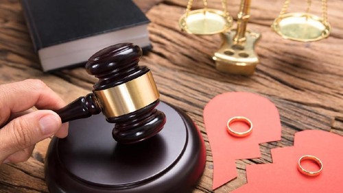 Judge hitting mallet by broken paper heart with rings and justice scale on wooden table