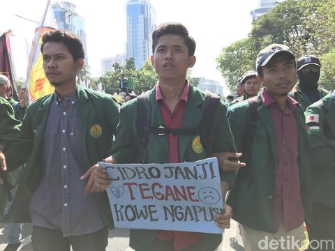 Mahasiswa membawa poster dalam demo bernada kecewa