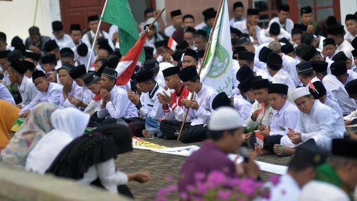 Sejumlah santri melakukan doa bersama di Taman Makam Pahlawan Bandar Lampung di Lampung, Senin (21/10/2019). Acara doa dan ziarah ke makam pahlawan tersebut diikuti oleh ratusan santri dari Pondok Sesantren Al-Hikmah Bandar Lampung sebagai rangkaian peringatan Hari Santri tahun 2019. ANTARA FOTO/Ardiansyah/wsj.