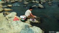 Seorang warga Jasinga, Bogor, memanfaatkan aliran sungai untuk mencuci pakaian.
