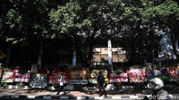 Beberapa warga melintas di depan karangan bunga ucapan selamat untuk Jokowi-Maruf.