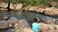Sejumlah anak-anak tengah bermain dialiran sungai sambil mandi dan berenang.