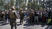 Para polisi militer bersenjata lengkap tersebut memperketat pengamanan usai aksi perusakan dan pembakaran yang mewarnai unjuk rasa massa yang memrotes kenaikan tarif transportasi umum. AP Photo/Luis Hidalgo.