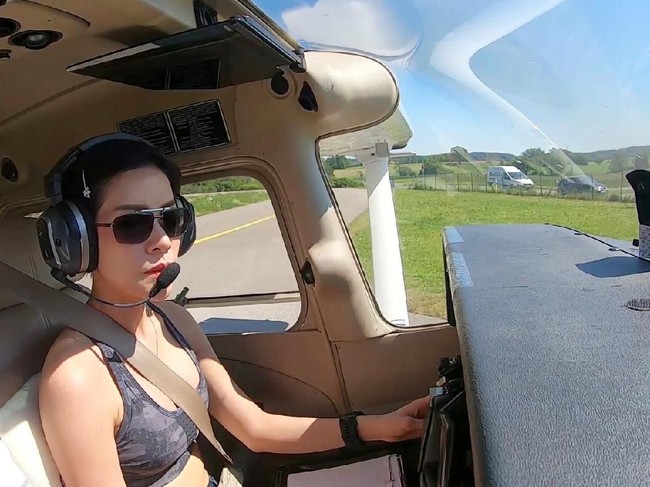 Saat menerbangkan pesawat, ia tampil sporty dengan kacamata hitam dan tank-top motif loreng. Terlihat ketangguhan di balik penampilannya ini. Foto: Reuters