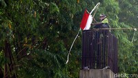 Seorang pria nampak memanjat fondasi beton yang berada di belakang gedung DPR RI, Jakarta, Selasa (22/10/2019). Ia membawa bendera Merah Putih saat memanjat beton tersebut. Sebelumnya ia juga membentangkan sebuah spanduk berisikan tagih janji jokowi.