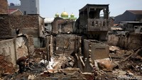 Beberapa warga bergotong-royong membersihkan barang-barang yang terbakar menggunakan sapu dan karung. Puing tersebut seperti bongkahan kayu, bantal, hingga pakaian.