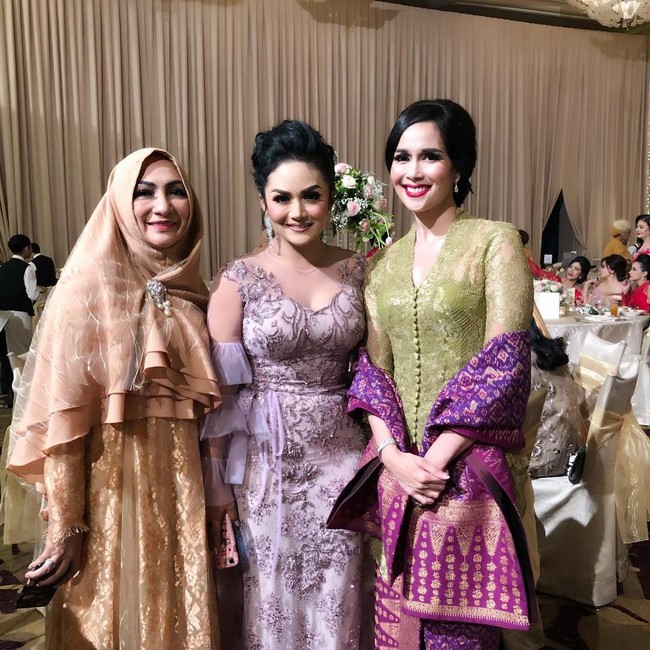 Selain batik, wastra nusantara yang juga sering jadi pilihan Loemongga ketika kondangan adalah songket. Seperti saat menghadiri sebuah pernikahan yang juga didatangi Krisdayanti ini, mantan Gadis Sampul itu memadukan kebaya hijaunya dengan kain dan selendang songket berwarna ungu. Foto: Dok. Instagram