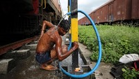Pemandangan ini sangat biasa bila kamu melihat orang dengan santainya berbusa dan mengusap badan di pinggir rel.  Ada juga yang menyuci saat kereta datang membawa air (Francis Mascarenhas/Reuters)