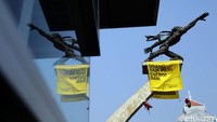 Para aktivis dari Greenpeace tersebut nampak memanjat ke puncak Patung Dirgantara untuk membentangkan spanduk raksasa bertuliskan Orang Baik Pilih Energi Baik.