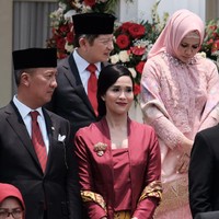 Istri Menteri Perindustrian Agus Gumiwang Kartasasmita, Loemongga Haoemasan, memilih kebaya kutubaru berwarna merah marun dengan desain yang simpel dipadukan kain batik Cirebonan bernuansa kuning. Ia mempercantik busananya dengan selendang batik dan korsase yang disematkan di dada kanan. Foto: Andhika/detikcom