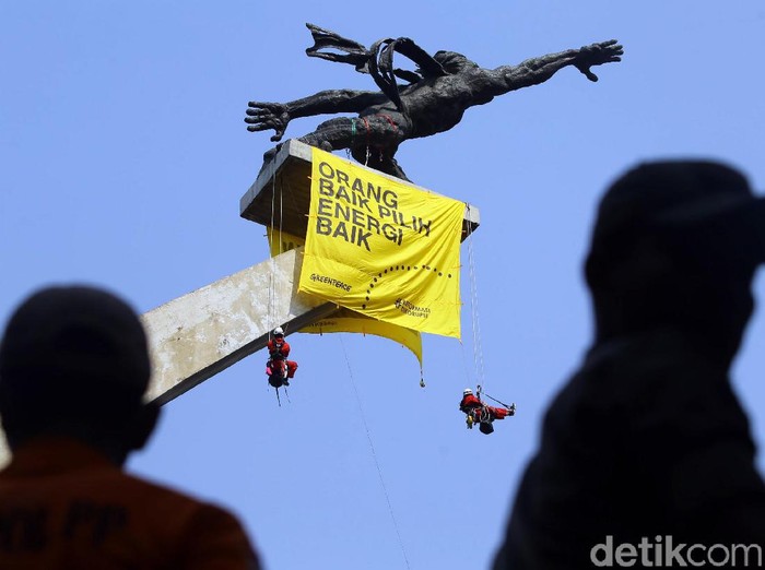 Aktivis dari Greenpeace Indonesia bentangkan spanduk Orang Baik Pilih Energi Baik di dua patung ikonik Jakarta. salah satunya Patung Dirgantara di Pancoran.