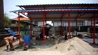 Sejumlah pekerja nampak sibuk dengan tugas masing-masing saat sedang membangun lapak pedagang kaki lima.