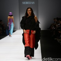 Aktris Hannah Al Rasyid mengenakan blouse hitam berhias payet, yang dipadankan dengan coat berwarna senada dan celana lebar merah.  Foto: Rachman Haryanto/detikcom