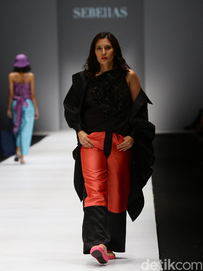 Aktris Hannah Al Rasyid mengenakan blouse hitam berhias payet, yang dipadankan dengan coat berwarna senada dan celana lebar merah.  Foto: Rachman Haryanto/detikcom