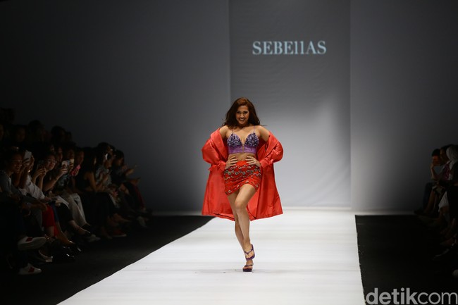 Nina demikian dia biasa disapa mengenakan coat berwarna merah yang dipadu kamisol ungu dan rok mini berhias ornamen bunga dan payet karya SEBE11AS. Foto: Rachman Haryanto/Detikcom