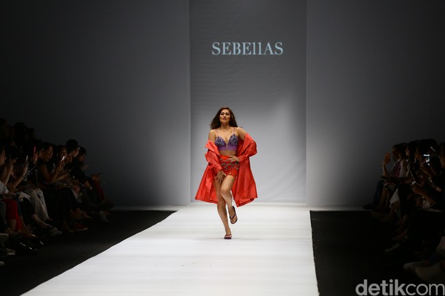 Karenina terlihat muncul di catwalk dengan busana serba merah. Aura seksi langsung terpancar begitu dia menampakkan diri dari belakang panggung dan berjalan ke tengah catwalk. Foto: Rachman Haryanto/Detikcom