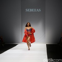 Karenina terlihat muncul di catwalk dengan busana serba merah. Aura seksi langsung terpancar begitu dia menampakkan diri dari belakang panggung dan berjalan ke tengah catwalk. Foto: Rachman Haryanto/Detikcom