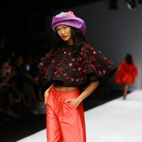 Kelly Tandiono tampil girlie memakai cape blouse berhias ornamentasi bunga dan celana serut warna coral berbahan taffeta. Hampir semua busana yang dikenakan para selebriti di fashion show ini merupakan hasil upcycling, di mana baju-baju lama dimodifikasi dan dirancang kembali menjadi busana baru yang lebih menarik. Foto: Rachman Haryanto/detikcom