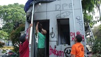 Sejumlah pekerja mulai memperbaiki pos yang rusak.