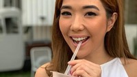 Menyeruput minuman kekinian berwarna pink, Gisell pose sambil tersenyum lebar. Meski sudah memiliki anak, tetapi Gisell masih tampak terlihat muda. Foto: Instagram @gisel_la