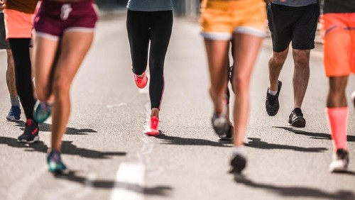 Unrecognizable athletic people running a marathon on the road.