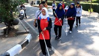 Para guru turut mendampingi peserta aksi gerak jalan tersebut dengan melakukan praktik pendampingan awas yang merupakan menuntun para peserta.