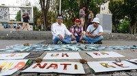 Mereka juga membawa poster bertulisan Tolak Pelanggar HAM dan Berbagi Lapak Rusak Demokrasi.