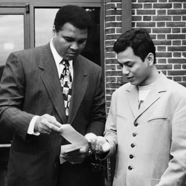 Wishnutama muda pernah berkesempatan bertemu dengan petinju legendaris Muhammad Ali. Saat Wishnutama mengunggah foto ini, tak sedikit netizen yang salah fokus pada penampilannya. Ada yang menyebut wajah tampannya mirip aktor Rami Malek. Foto: Dok. Instagram Wishnutama