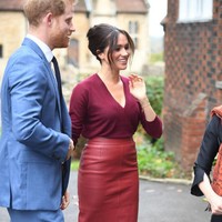 Meghan memadukan atasan lengan panjang berbelahan dada rendah dengan rok kulit high-waist senada. Turut melengkapi gaya istri Pangeran Harry itu, sepasang stiletto suede yang meninggalkan kesan elegan. (Foto: Getty Images)