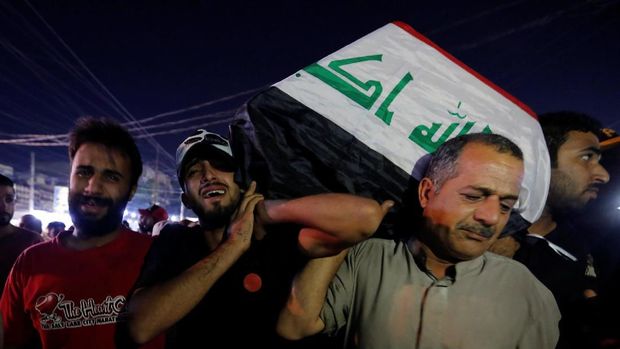Warga Irak menggotong peti mati salah satu demonstran yang tewas