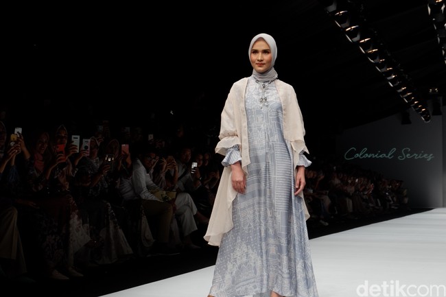 Inilah penampilan selebgram Dwi Handayani bergaya di catwalk dengan outer warna cream dan dress biru yang bertemakan keindahan kerajaan zaman dulu di Indonesia. Foto: Gresnia/Detikcom