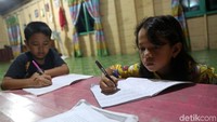 Sejumlah anak-anak di Desa Sabang Mawang, Pulau Tiga, Kabupaten Natuna, Kepulauan Riau, sedang mengerjakan tugas sekolah di kala malam.