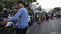 Petugas berusaha mengatur arus lalu lintas.