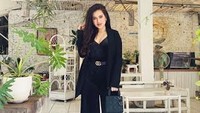 Bergaya modis dengan setelan serba hitam, Ini pose eksotis dari PA di sebuah kafe. Tampak pemandangan kafe yang serba putih dengan pemandangan tanaman hijau. Foto: Instagram @putriameliaaa