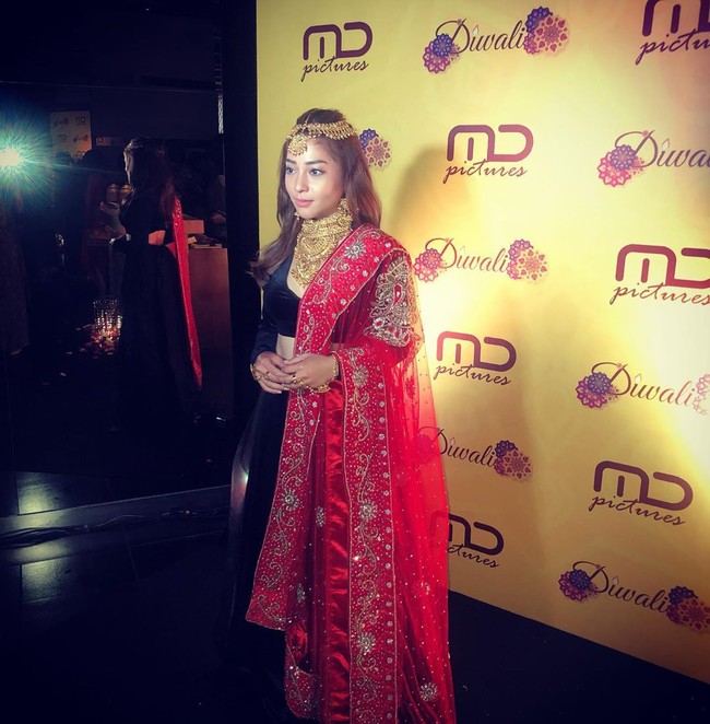 Nikita Willy bergaya glamour dengan busana lehenga hitam yang dipadukan dengan kain merah. Dia melengkapi penampilannya dengan kalung dan hiasan kepala serba emas. Foto: Dok. Instagram