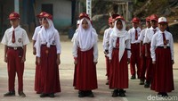 Dengan menggunakan seragam merah putih lengkap beserta topi dan dasi, para siswa tersebut berbaris rapi untuk mengikuti upacara.