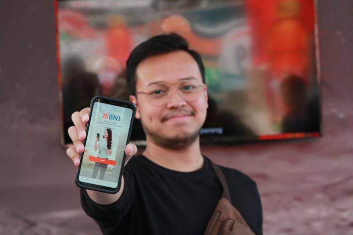 Seorang milenial sedang menunjukkan aplikasi Pembukaan Rekening Digital BNI/Foto: Dok. BNI Seorang milenial sedang menunjukkan aplikasi Pembukaan Rekening Digital BNI/Foto: Dok. BNI
