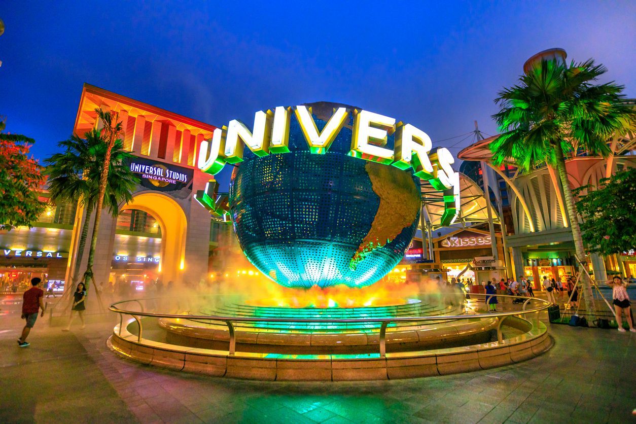 Singapore - May 2, 2018: Universal Studios world globe in green light, with tourists visiting this Hollywood movie theme park in Sentosa island.