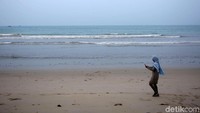 Seorang pengunjung sedang memotret pemandangan di Pantai Tanjung, Kabupaten Natuna, Kepulauan Riau.