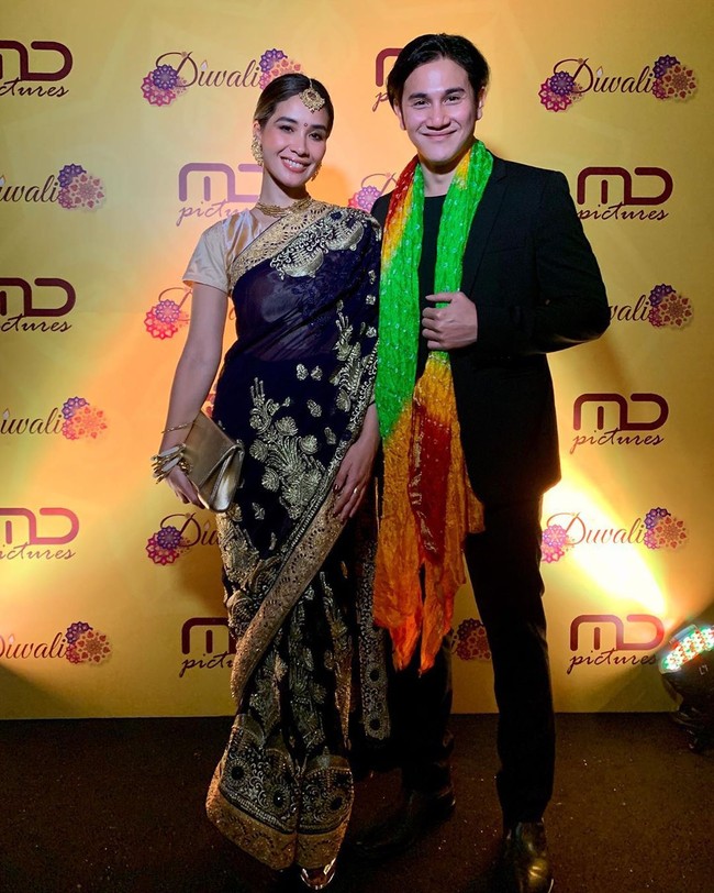 Kain sari hitam dengan detail benang emas jadi pilihan Marsha Timothy yang hadi di perayaan Diwali MD Pictures bersama suaminya Vino G. Bastian. Aksesori serba emas mulai dari sepatu, tas hingga anting melengkapi gaya Marsha. Foto: Dok. Instagram