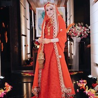 Olla Ramlan yang sudah berhijab juga bergaya ala wanita India dengan dress dan kerudung merah - emas. Olla melengkapi penampilannya dengan membawa tas emas yang bentuknya mirip lampu. Foto: Dok. Instagram