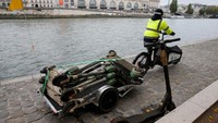 Seorang pekerja di startup skuter Lime, Paris membagikan cerita bagaimana dia mengumpulkan skuter yang berada di Sungai Seine (Pascal Rossignol/Reuters)