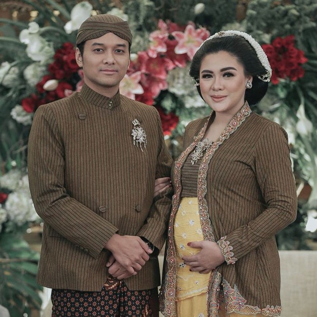 Vicky Shu dan Ade Imam selalu mengusung adat Jawa kental dalam perayaan kehidupan mereka. Mulai dari pernikahan hingga tujuh bulanan. Vicky dan suami kompak memakai baju adat bermotif lurik warna cokelat dan kain batik motif truntum. Foto: Instagram/@vickyshu