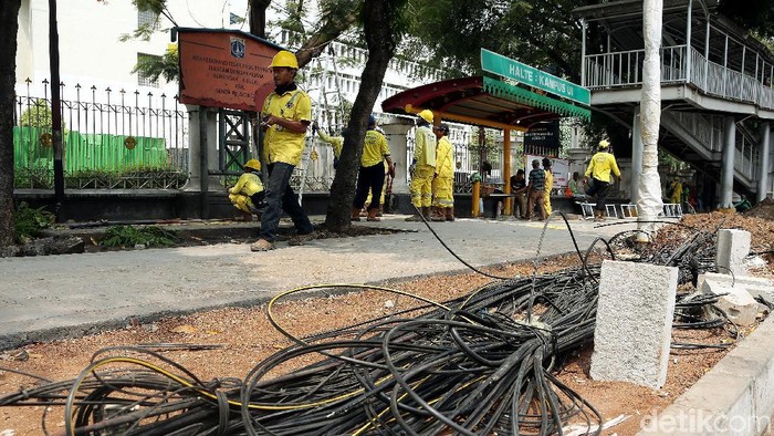 Petugas Suku Dinas Bina Marga DKI Jakarta menertibkan kabel fiber optik dan tiang penyangga yang semrawut di sepanjang Jalan Raya Salemba, Jakarta.