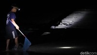 Warga mengenakan senter dan membawa serta jaring saat sedang berburu ikan dan kepiting di malam hari.