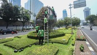 Sejumlah petugas menata pot-pot bunga di taman Jalan Medan Merdeka Selatan.