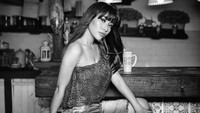 Meski diberi efek black and white pada fotonya, aura seksi Liza Aditya tetap terpancar. Jadi salah fokus dengan gelas yang berada di atas meja belakang Liza Aditya. Foto: Instagram @lzdtya