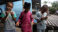 Anak-anak tersebut membuat sendiri layang-layang yang akan mereka gunakan untuk bermain.