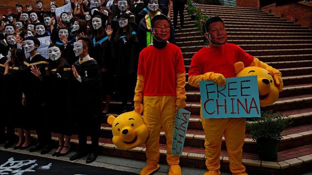 Men wearing Winnie the Pooh costumes and masks depicting Chinese President Xi Jinping pose for a photoshoot of a graduation ceremony to support anti-government protest at the Hong Kong Polytechnic University, in Hong Kong, China October 30, 2019. REUTERS/Tyrone Siu