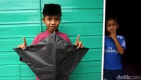  Seorang anak menunjukkan layang-layang yang berhasil dibuat bersama kawan-kawannya. Layang-layang itu pun siap untuk diterbangkan.